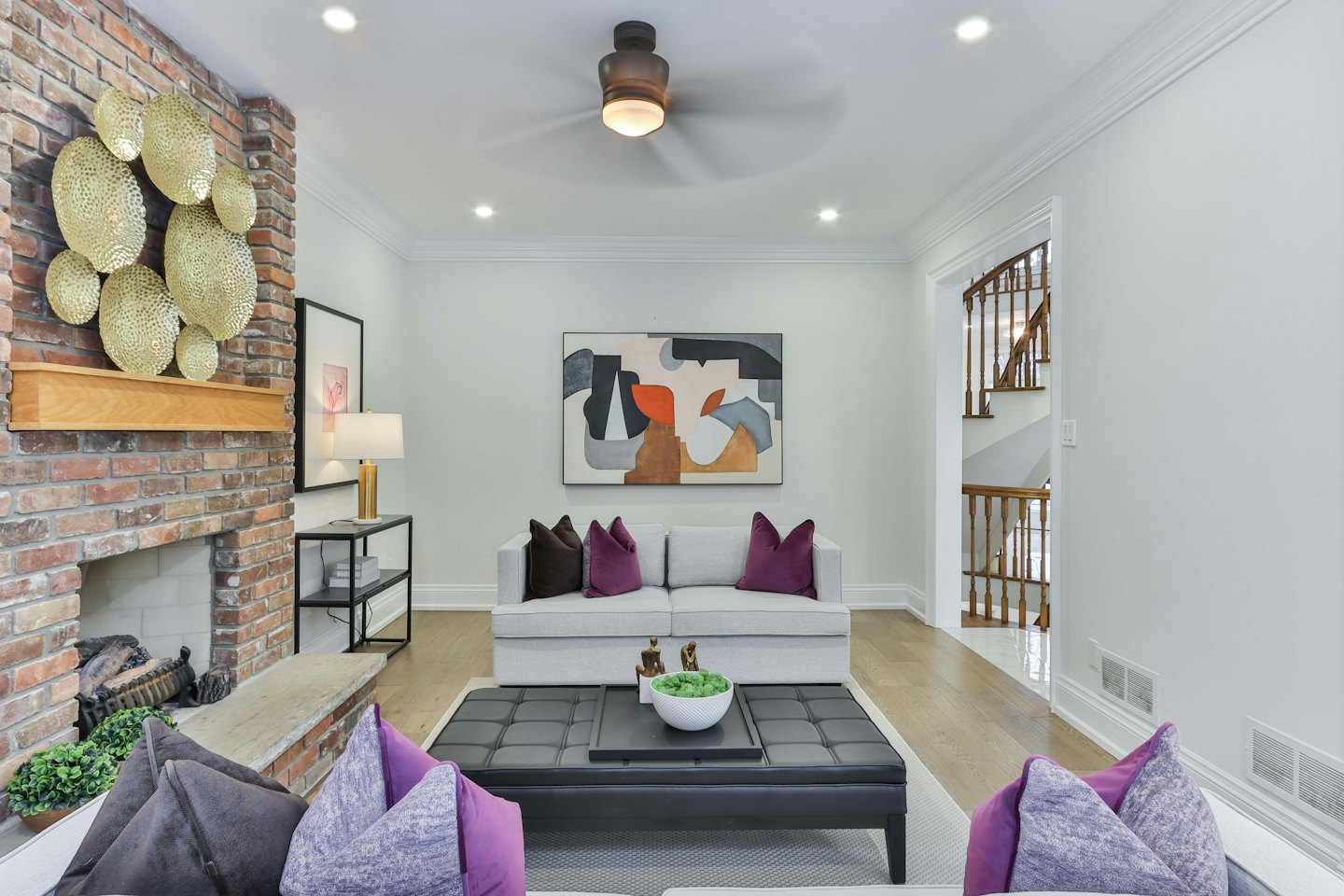 Modern living room featuring a grey sofa and brick fireplace.
