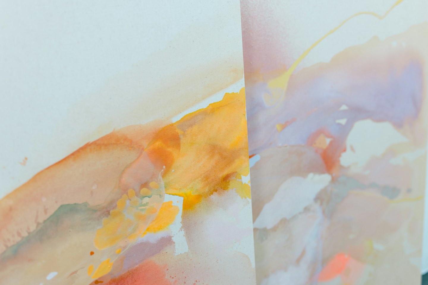 Abstract watercolor painting with blended orange and purple shapes.