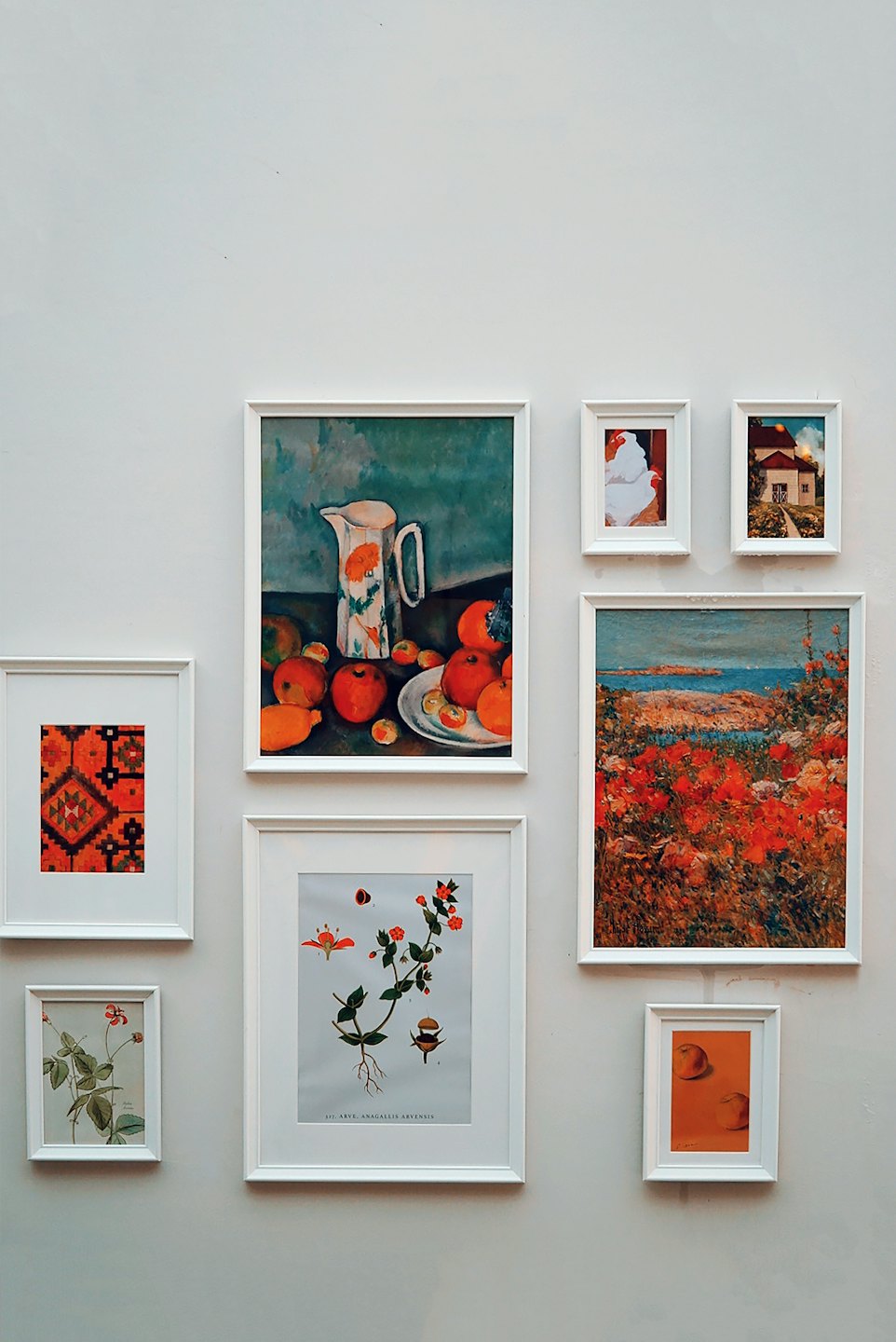 A gallery wall displays multiple framed artworks on a wall.